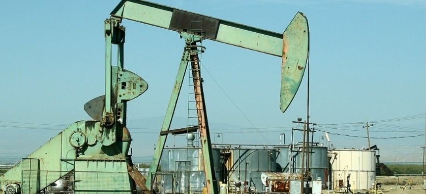 Oil pumpjack operating in a field under a clear sky