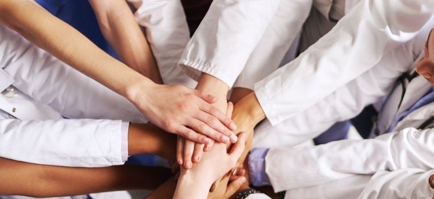 Healthcare team joining hands in a show of unity