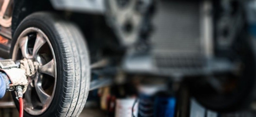 Mechanic removing a wheel with an impact wrench in a repair shop