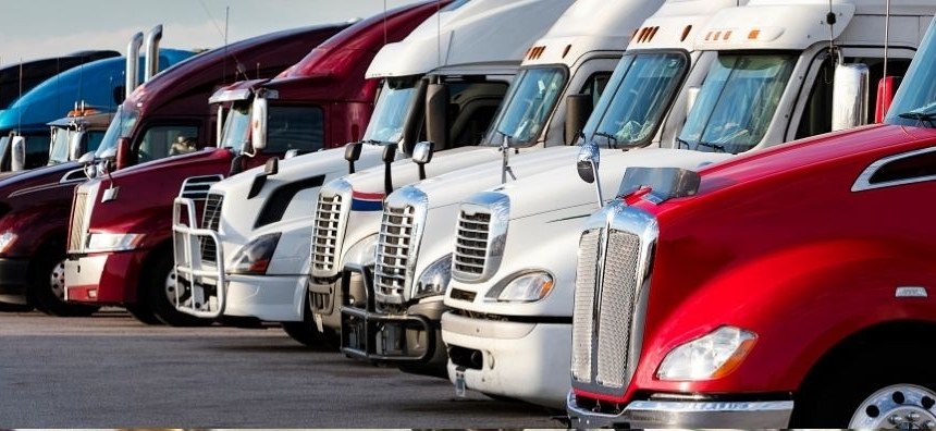 Row of semi-truck tractors parked at a terminal