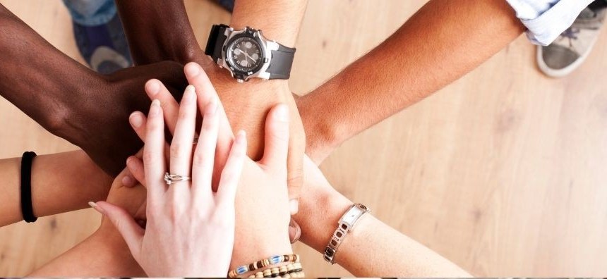 Group of volunteers stacking hands together