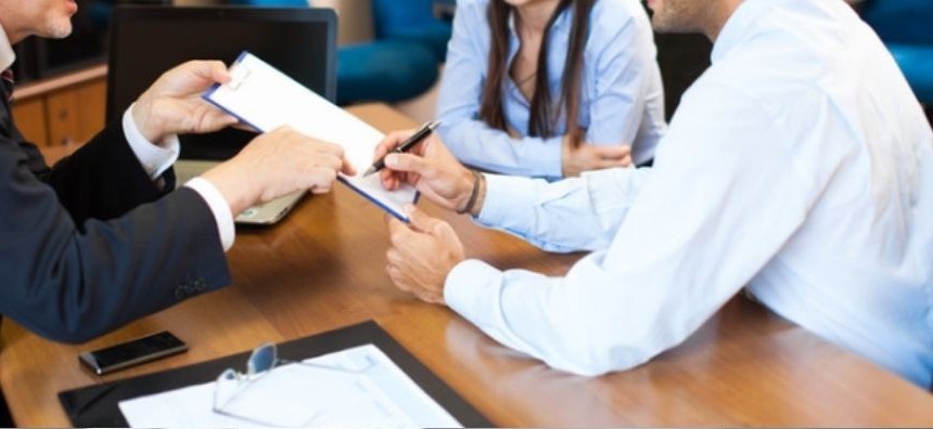 Advisors reviewing a document with clients at a conference table